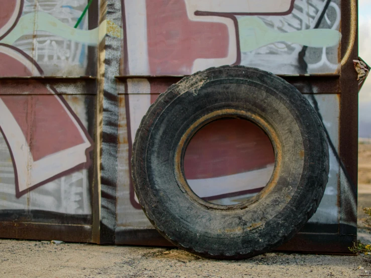 an old worn tire leaning against a wall