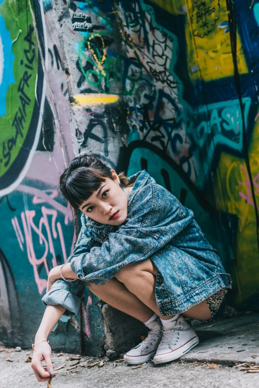 a little boy sitting against a colorful wall with his feet in the air