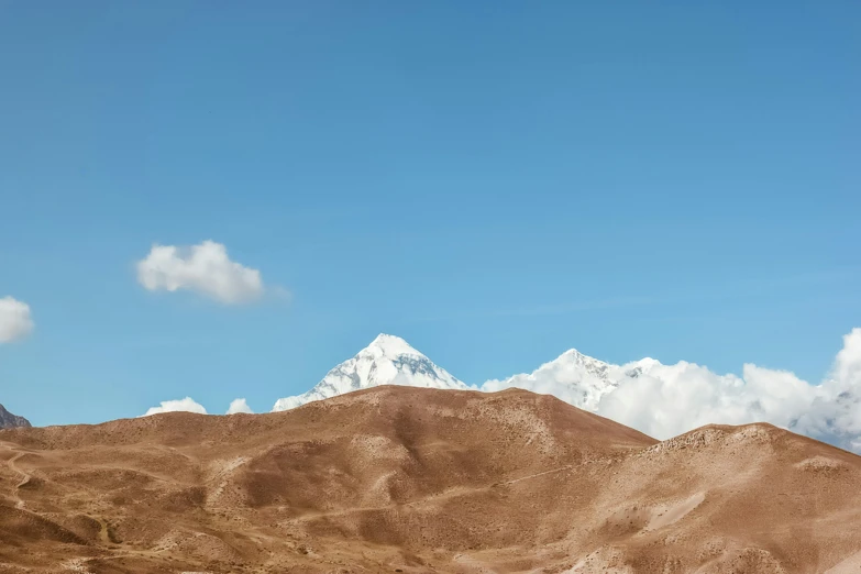 a large mountain that has a few clouds