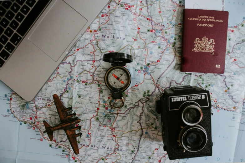 an old camera, a map and a travel book are sitting on a table