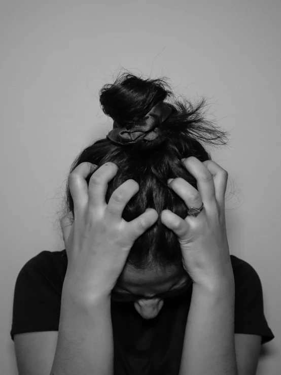 a person holding their head with their hands to their face