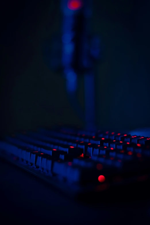 a dark computer keyboard glowing red in the dark