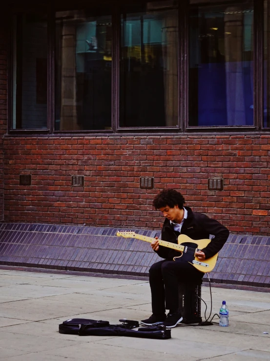 a man playing a guitar on a street corner