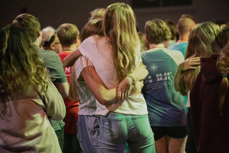 two girls hug in the middle of a crowded area