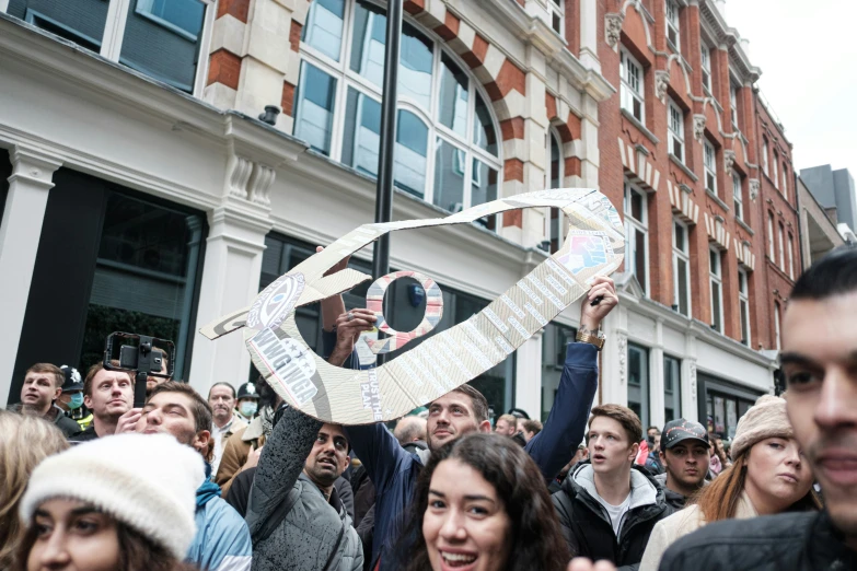 some people and a woman and the man is holding up a piece of paper