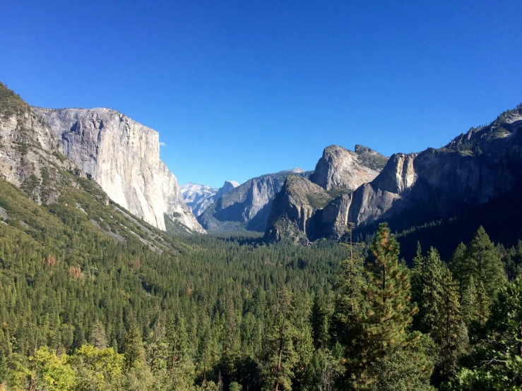 a mountain with some trees and mountains in the background