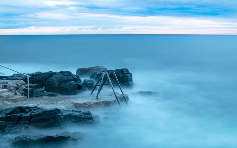 a long exposure pograph of blue water with rocks