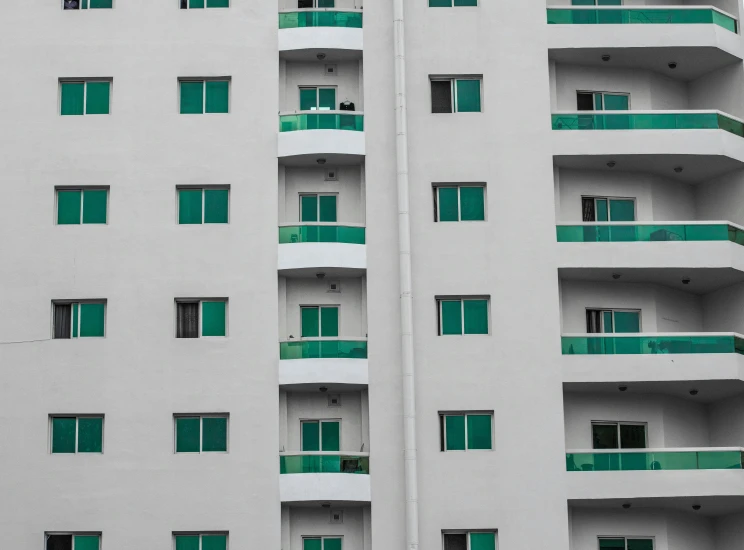 a white building with balconies and green shutters