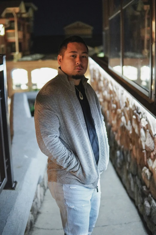 a man standing near a wall outside a building