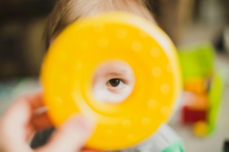 a young child holding a frisbee to the camera