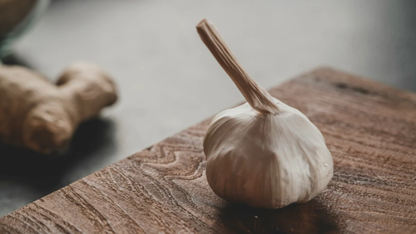 a single garlic sitting on top of a wooden table