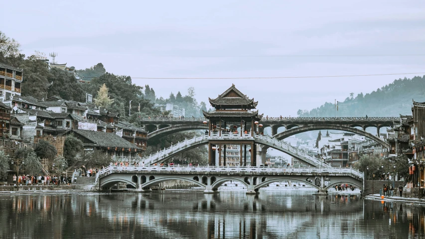 the bridge and buildings that overlooks the river in a city