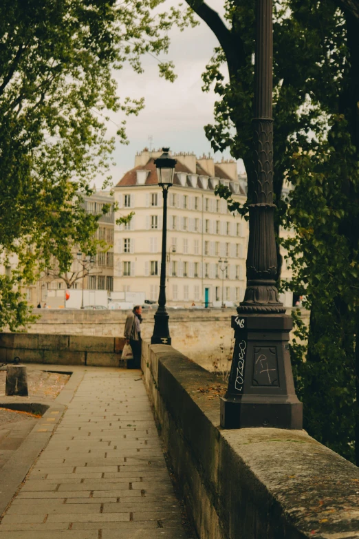 a man sits on a stone path under a lamppost