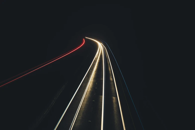 the night sky shows lines of light on the road