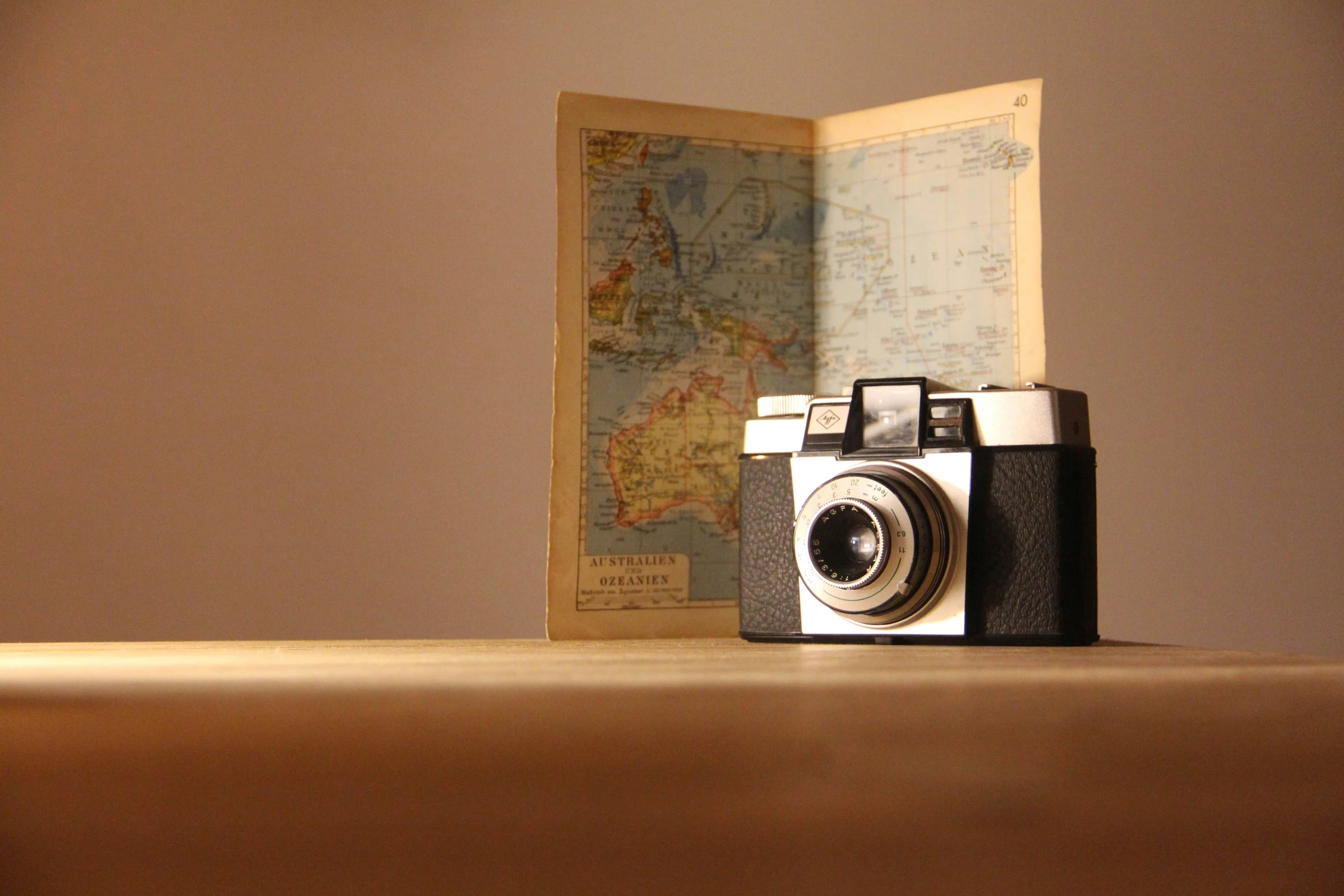 old fashioned digital camera with world map in background