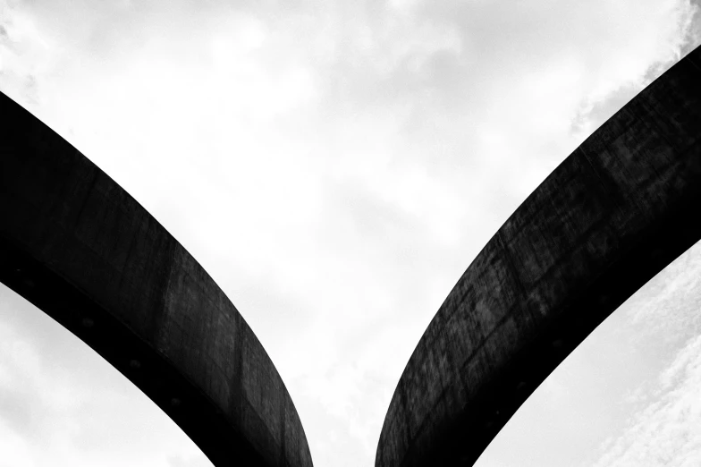 view looking up into the sky from underneath two large arches