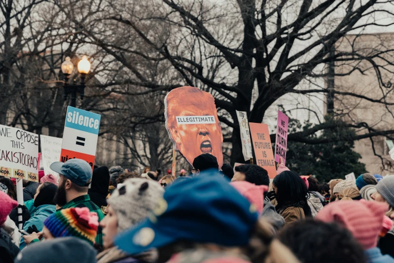 a large crowd is standing near some signs