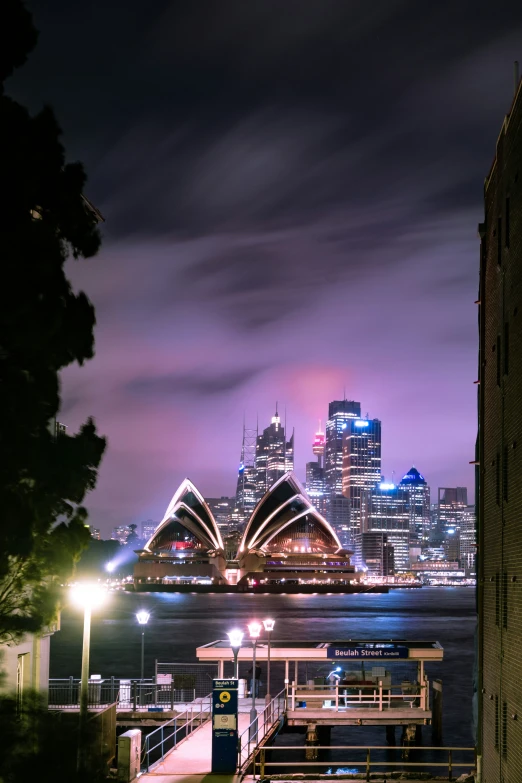 a building next to water at night with lights on