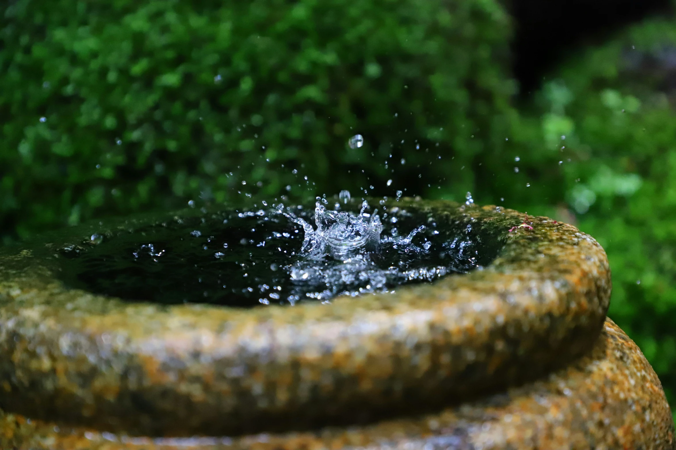 water coming from the base of an old statue