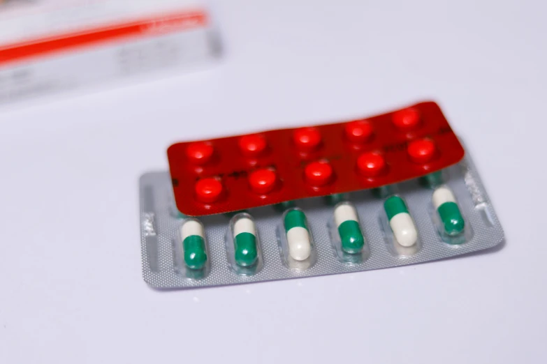 pills in packs are laying next to a white background