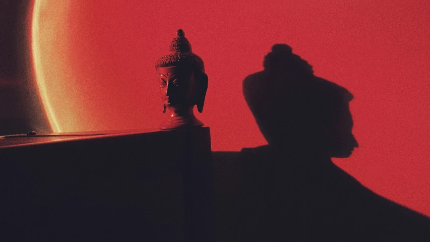 shadow of man on shelf next to wall with red backdrop