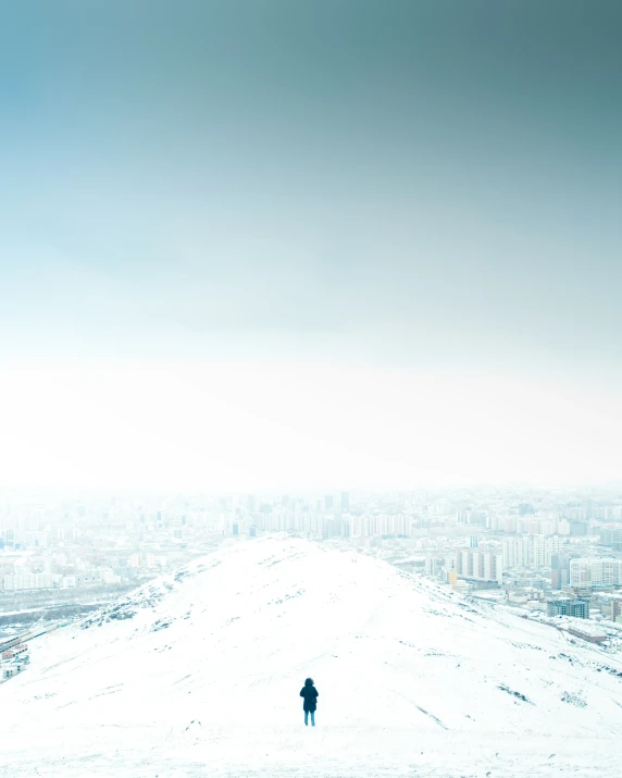 lone person walking across an empty snowy field