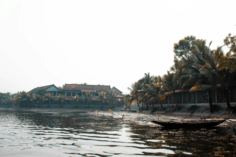 a house sits on the side of a lake with two boats floating around