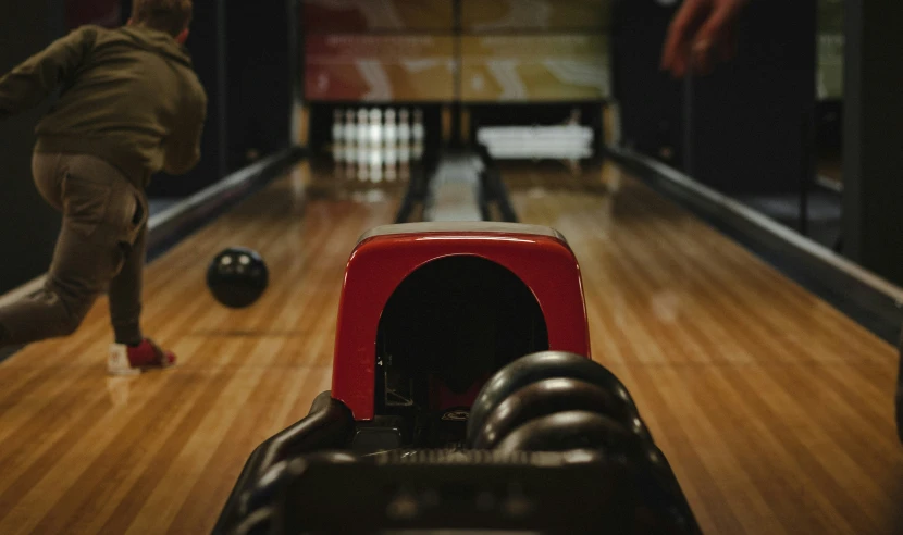 a woman is bowling the ball in a bowling alley