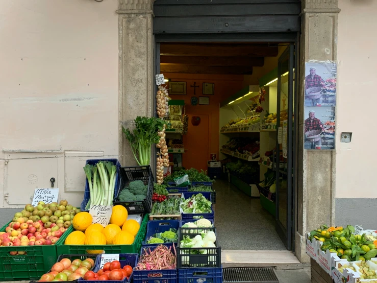 a variety of fruits and vegetables in crates sitting outside of a store