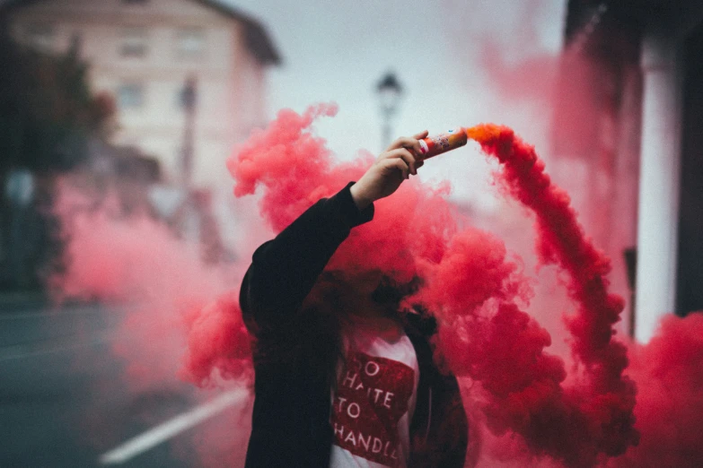red smoke wands on a person holding a sign