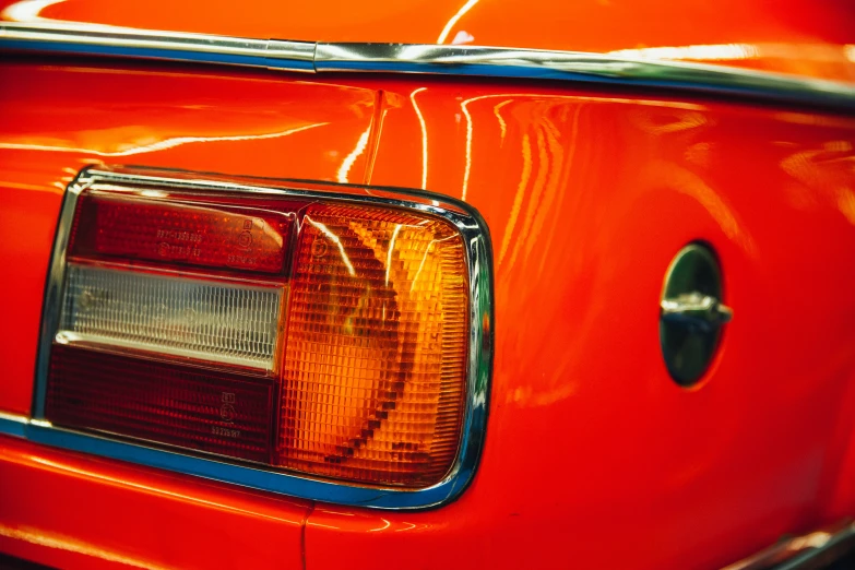 a bright orange mustang sitting on top of a car