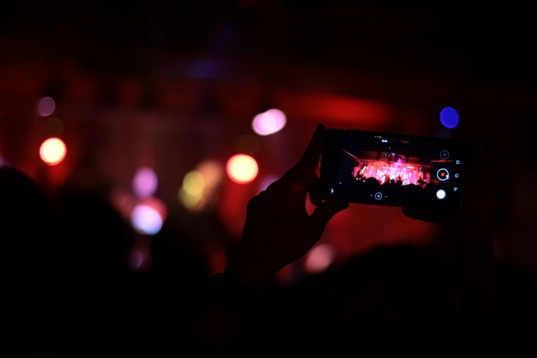 a person taking pictures in the dark with their cell phone