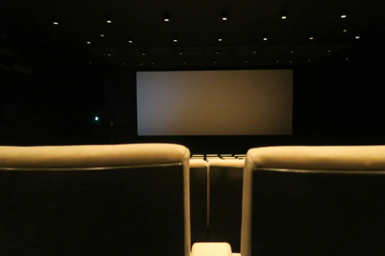 an empty seat with a projector screen in the back