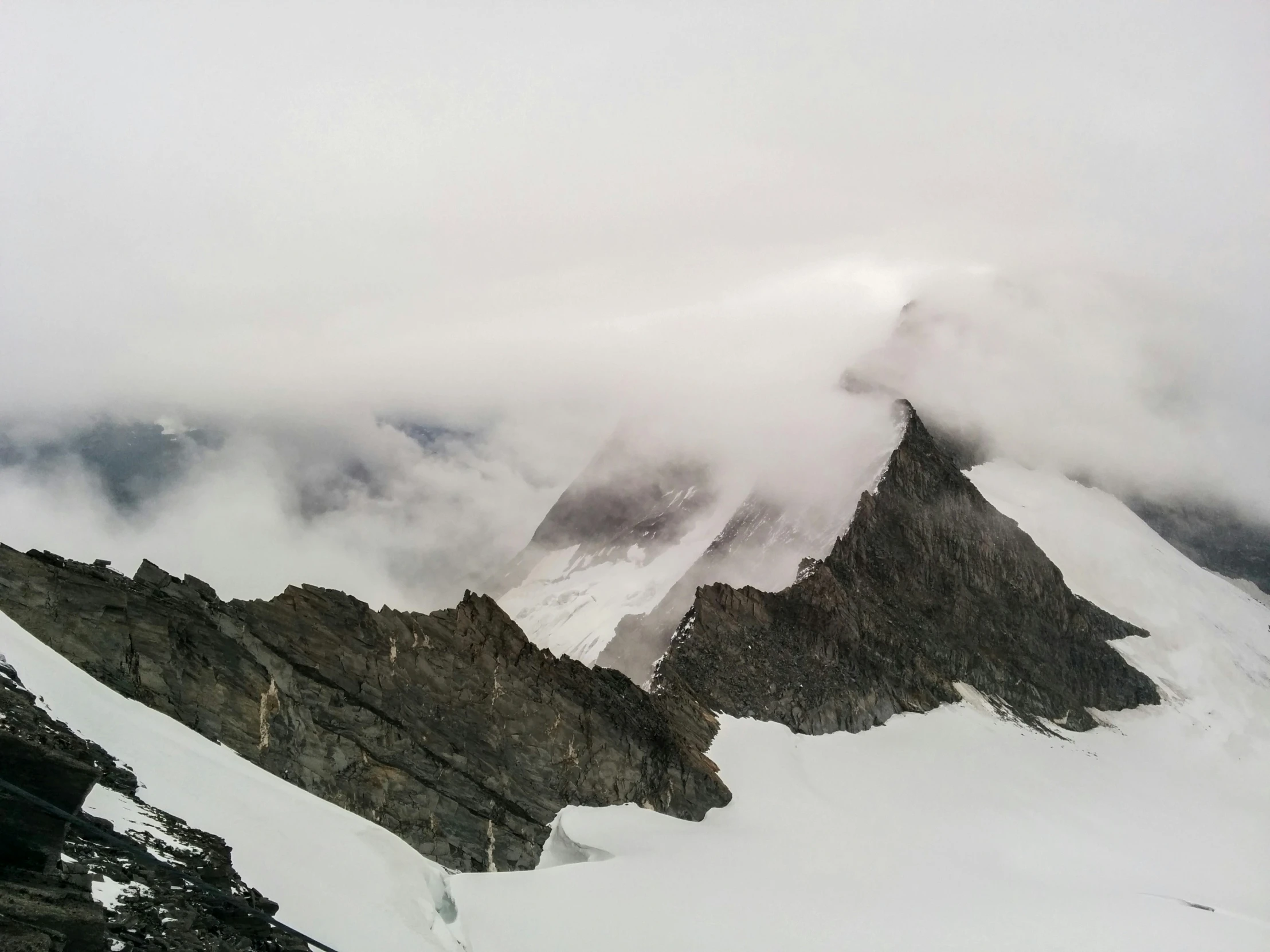 a mountain is covered in fog and some clouds