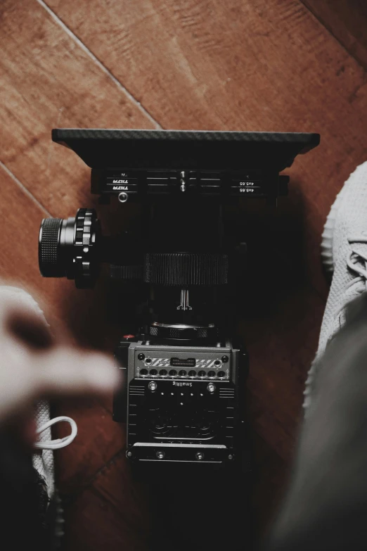 the legs of someone looking down at an old fashioned camera