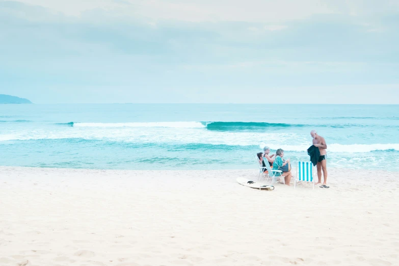 two people on a beach chair watching waves