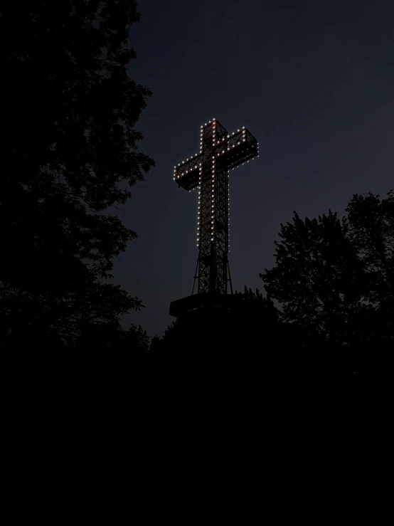 a night s of the illuminated cross on a hill