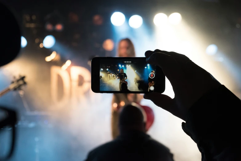 someone taking a picture in the dark of a stage