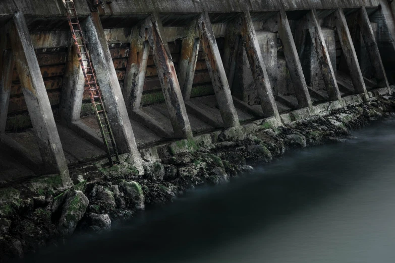 an old dirty concrete walkway next to the water