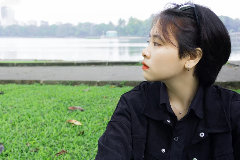 a woman looks toward the horizon in front of water