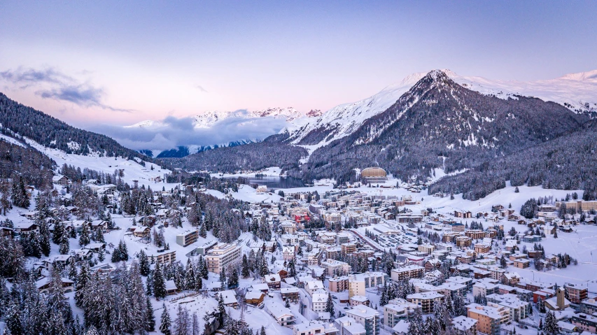 a mountain village is nestled on a snowy hill