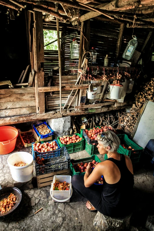 a lady selling fresh fruit inside a rustic market