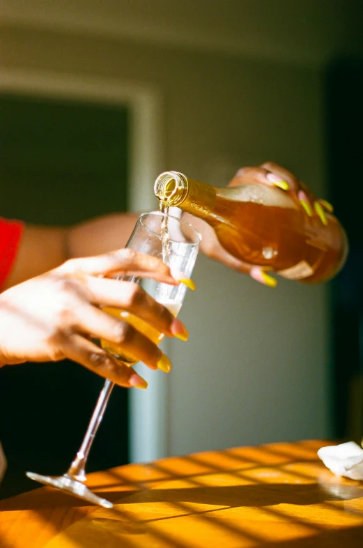 the woman is pouring a drink into her glasses