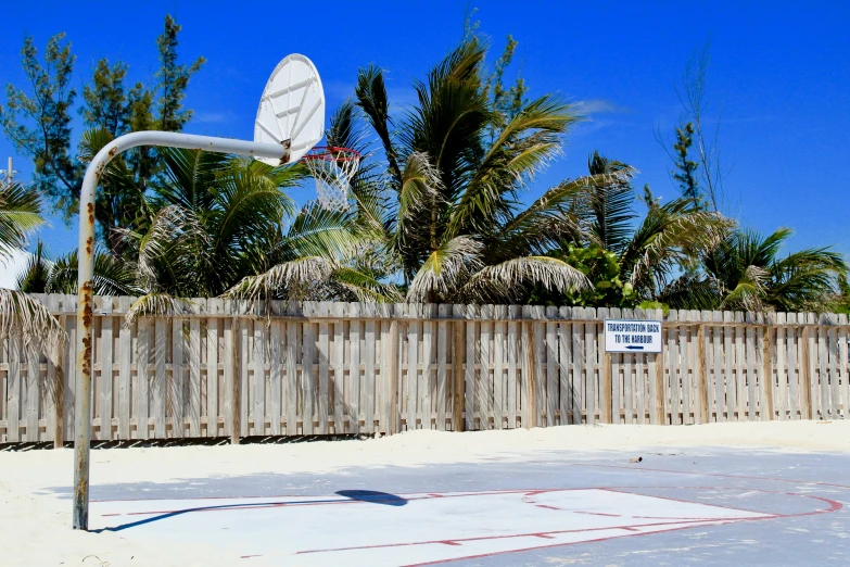 a basketball hoop next to a tall fence