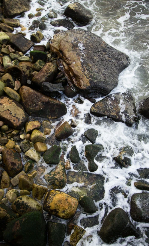 rocks in the water and a few white bubbles