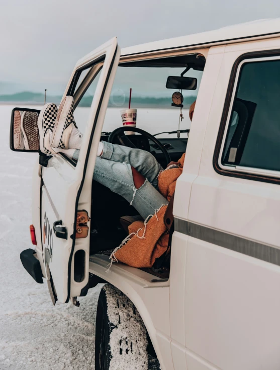 a woman sleeping in the back seat of a pick up truck