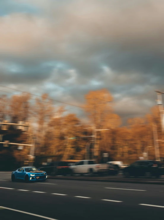 a road with some cars on it next to a bunch of trees