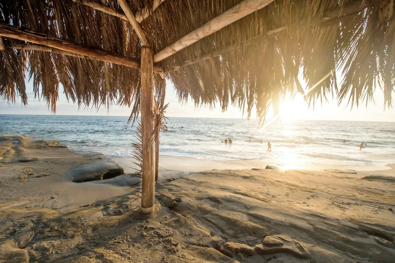 a hut is on a beach under the sun