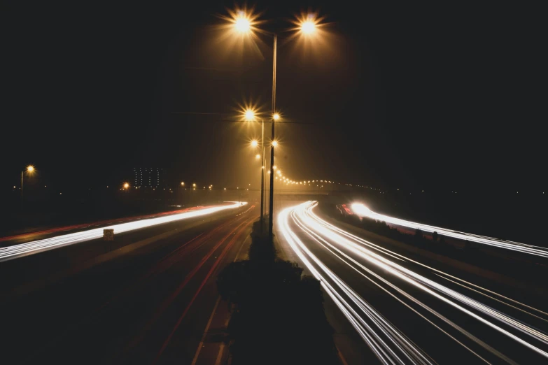 night time view of highway with cars streaking past at an angle