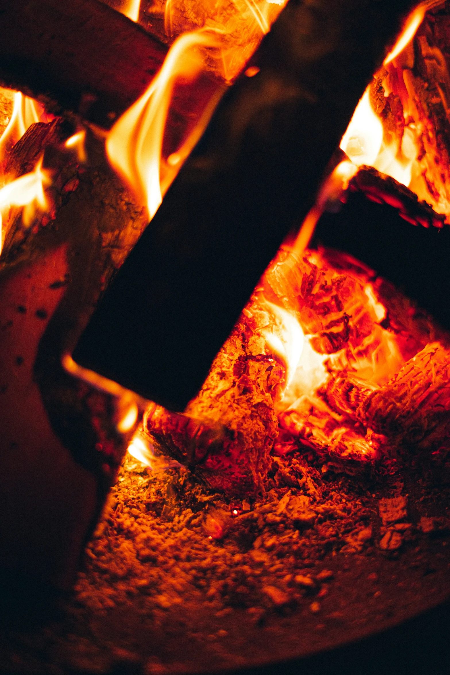 a pizza sitting next to the fire on a counter top